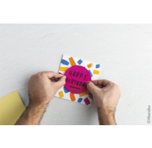 Person bastelt eine Geburtstagskarte mit der Aufschrift Happy Birthday.