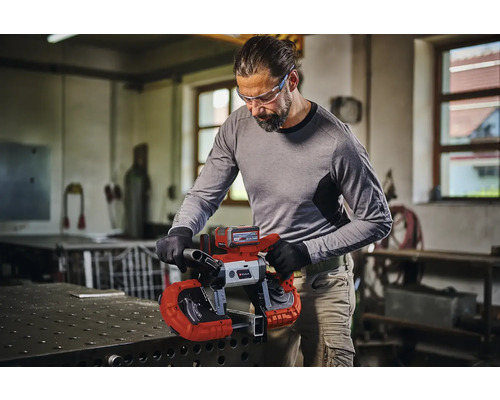 Mann schneidet Metall mit einer Einhell Akku-Bandsäge in einer Werkstatt