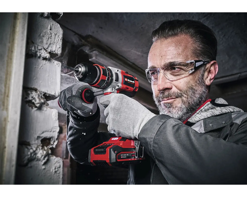 Mann bohrt mit einem Einhell Akku-Bohrschrauber in eine Mauer.