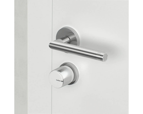 Türklinke aus Edelstahl mit tedee Smart Lock an einer weißen Tür.