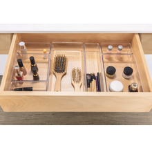 Geöffnete Schublade mit durchsichtigen Organizer-Einsätzen für Kosmetikartikel und Bürsten.
