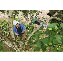 Mann mit Helm und Sicherheitsausrüstung benutzt eine Hochentaster Säge von Bosch in einem Baum.