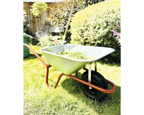 Schubkarre mit Gartenabfällen im Garten