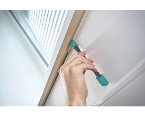 Hand verwendet Reinigungswerkzeug am Türrahmen