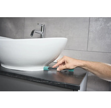 Szene eines Badezimmers mit einem Waschbecken und einer Person, die eine Reinigungsbürste benutzt