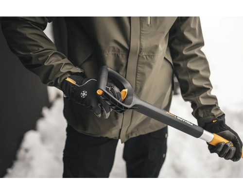 Person hält eine Fiskars X-series Schneeschaufel
