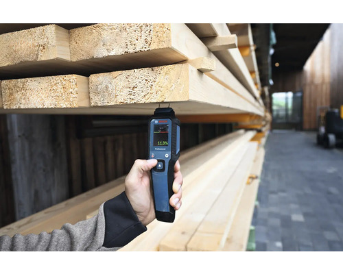 Eine Person misst die Holzfeuchtigkeit mit einem Feuchtigkeitsmesser von Bosch.
