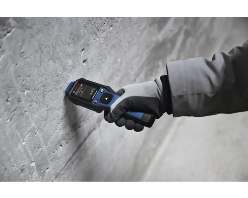 Hand mit Bosch Feuchtigkeitsmessgerät an einer Betonwand