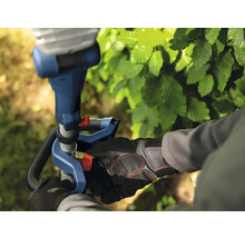 Nahaufnahme einer Person, die mit einer Heckenschere arbeitet, mit Fokus auf die Bedienung und Sicherheitsausrüstung.