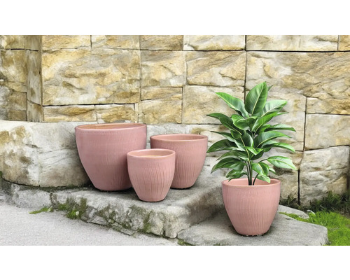 Blumentöpfe in verschiedenen Größen vor einer Steinmauer