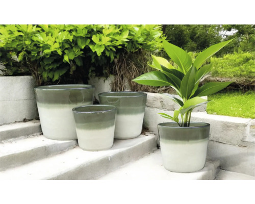 Verschieden große Pflanzgefäße auf einer Treppe im Außenbereich.