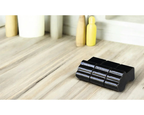 Schwarzer Fliesenschlitten auf hellem Untergrund