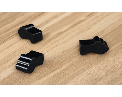 Drei schwarze Kabelclips auf einer Holzoberfläche