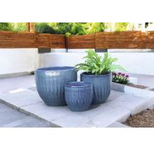 Drei Pflanzgefäße in unterschiedlichen Größen auf einer Terrasse