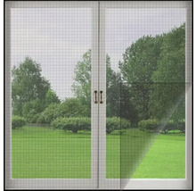 Insektenschutzgitter vor einem Fenster mit Blick auf einen Garten