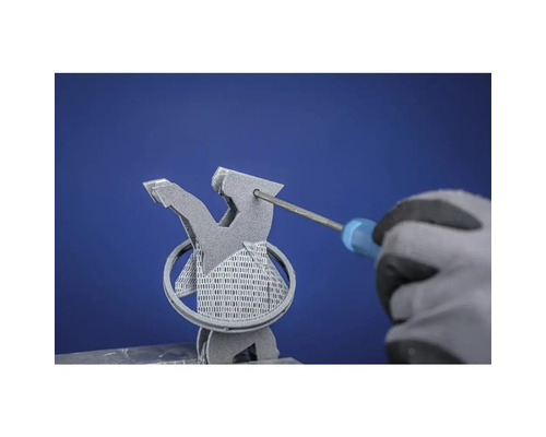 Ein Mann mit Handschuhen entfernt mit einem Schraubendreher Stützstrukturen von einem 3D-gedruckten Objekt.