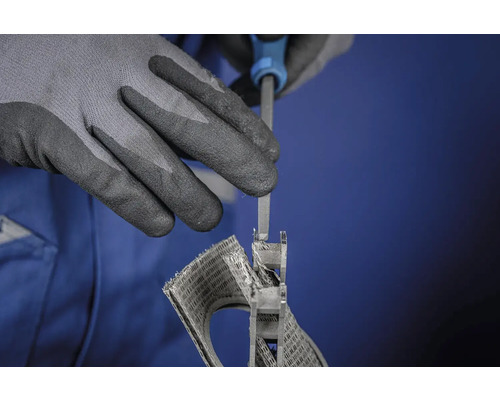 Eine Person bearbeitet ein Bauteil mit einer Feile und trägt dabei Schutzhandschuhe.