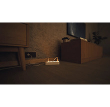 Mehrfachsteckdose mit eingesteckten Stromkabeln in einem Wohnzimmer.