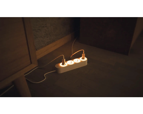 Steckdosenleiste mit angeschlossenen Geräten auf dem Boden