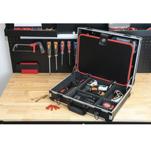 Offener Werkzeugkoffer mit Werkzeugen auf einer Werkbank