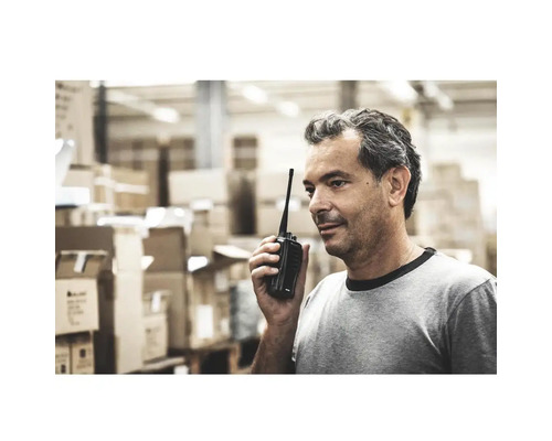 Ein Mann benutzt ein Funkgerät in einem Lagerhaus.