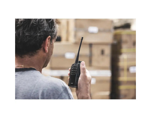 Eine Person hält ein Funkgerät in der Hand.