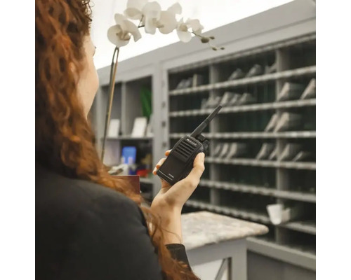 Frau hält ein Funkgerät der Marke Midland in der Hand