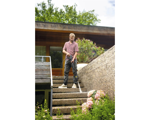 Mann reinigt Außentreppe mit Hochdruckreiniger.