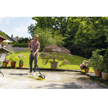 Mann reinigt Terrasse mit einem Terrassenreiniger