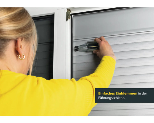Frau befestigt Rollladen mit Montagehilfe an Führungsschiene