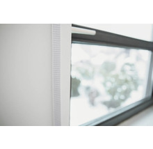 Detailansicht eines weißen Rollos neben einem Fenster