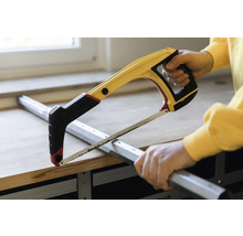 Mann sägt Metallprofil mit einer Bügelsäge