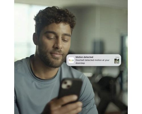 Mann erhält Benachrichtigung über Bewegungserkennung an der Haustür auf seinem Smartphone