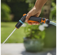 Eine Hand hält eine Gardena Gartenspritze, aus der Wasser austritt.