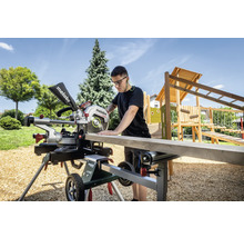 Mann sägt Holzbrett mit Metabo Kapp- und Gehrungssäge im Garten