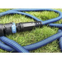 Blauer flexibler Gartenschlauch mit Kupplung auf Gras