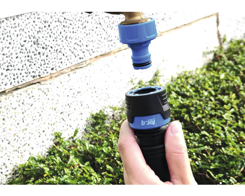 Gartenschlauch-Kupplung wird an einen Wasserhahn angeschlossen