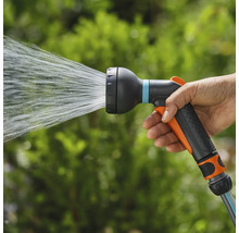 Eine Hand hält eine Gartenspritze, aus der Wasser austritt.