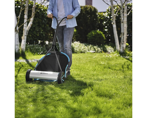 Person schiebt einen Gardena Handrasenmäher über einen Rasen.