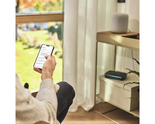 Eine Person bedient eine Gartenbewässerungs-App auf einem Smartphone