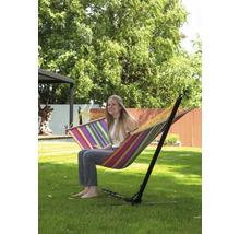 Frau sitzt in einer gestreiften Hängematte mit Gestell im Garten.