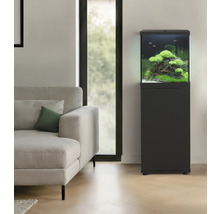 Eingerichtetes Aquarium mit Unterschrank im Wohnzimmer neben einem Sofa