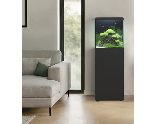 Eingerichtetes Aquarium mit Unterschrank im Wohnzimmer neben einem Sofa