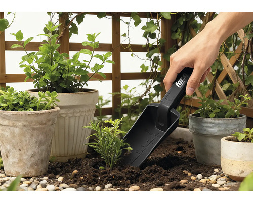 Gartenszene mit Pflanztöpfen, umgebender Begrünung und einer Person, die eine Pflanzschaufel benutzt.