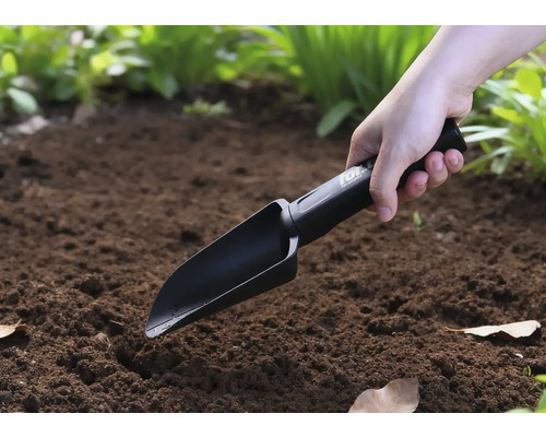 Eine Person benutzt eine Handschaufel im Garten.