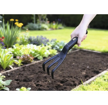 Gartenkralle im Einsatz in einem Gemüsebeet.