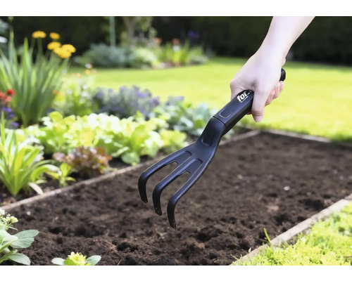 Gartenkralle im Einsatz in einem Gemüsebeet.