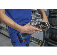 Eine Person hält eine Presszange für Kabel in der Hand