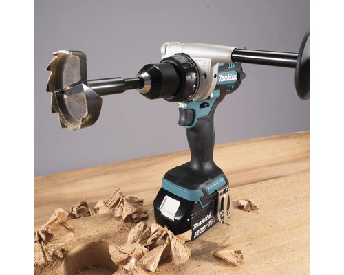 Akkubohrmaschine mit Holzbohrer und Span auf Holzoberfläche