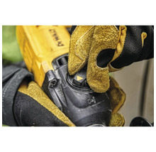 Detailaufnahme einer Person, die mit Schutzhandschuhen einen Winkelschleifer bedient